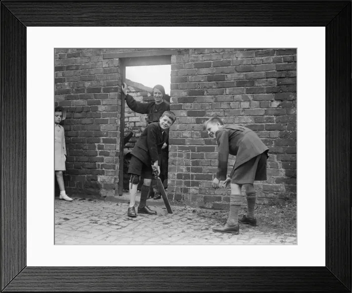 Framed Print : Young boys playing cricket up against a wall. Boy batting has artificial leg. c Framed Print : Young boys playing cricket up against a wall. Boy batting has artificial leg. c