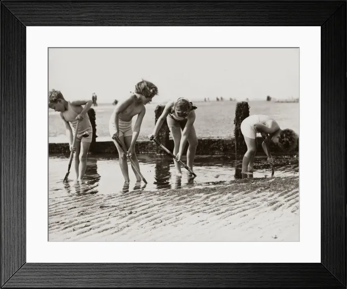 Framed Print : Young children looking for crabs and other beach life hiding in the sands on the beach Framed Print : Young children looking for crabs and other beach life hiding in the sands on the beach