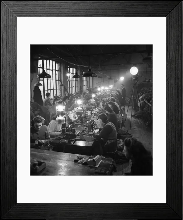 Framed Print : Factory girls at clothing works in East London use candle powered search lights for