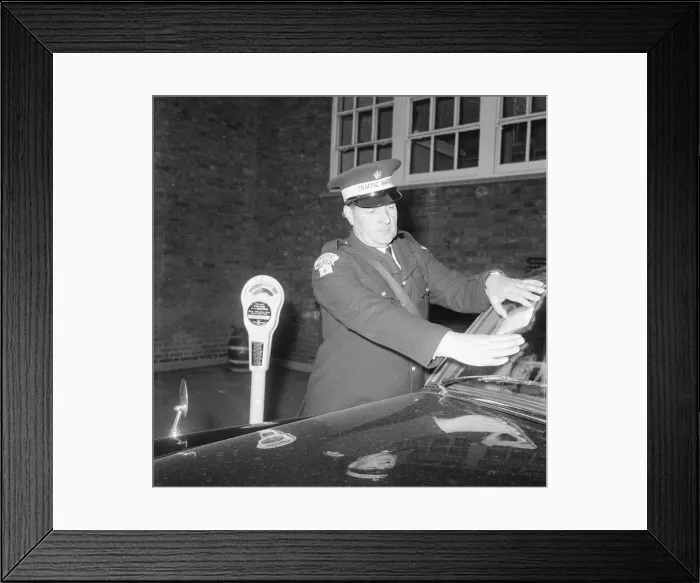 Framed Print : Traffic warden during training sticking fine on window screen parking clock Framed Print : Traffic warden during training sticking fine on window screen parking clock