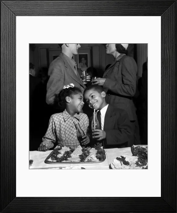 Framed Print : Boy and Girl aged 7 enjoy a drink and food at a reception for the cast of Porgy and Bess