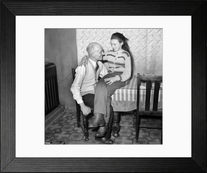 Framed Print : Eva Spiers with her father in her home still wearing the slacks that caused her to be Framed Print : Eva Spiers with her father in her home still wearing the slacks that caused her to be