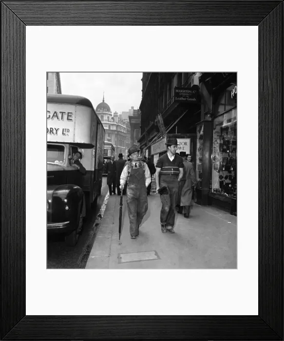 Framed Print : Bernie Crisp and friend stroll down a London Street wearing a bowler Framed Print : Bernie Crisp and friend stroll down a London Street wearing a bowler