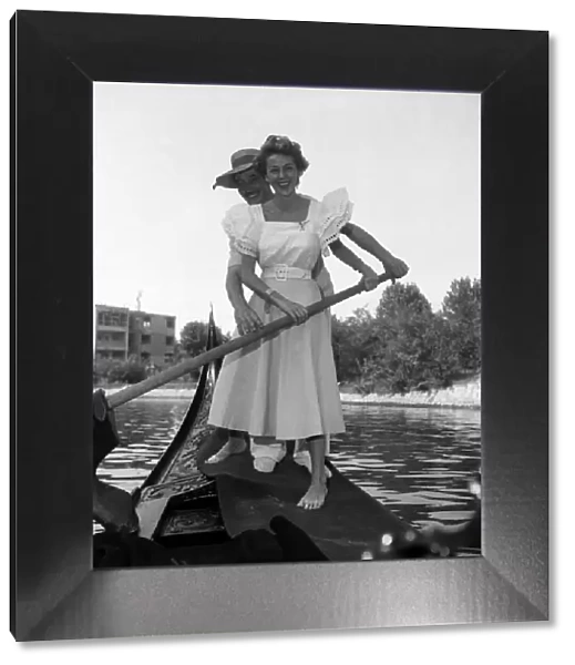 Ann French, actress posing with a gondolier in Venice, Italy. September 1952 C4555
