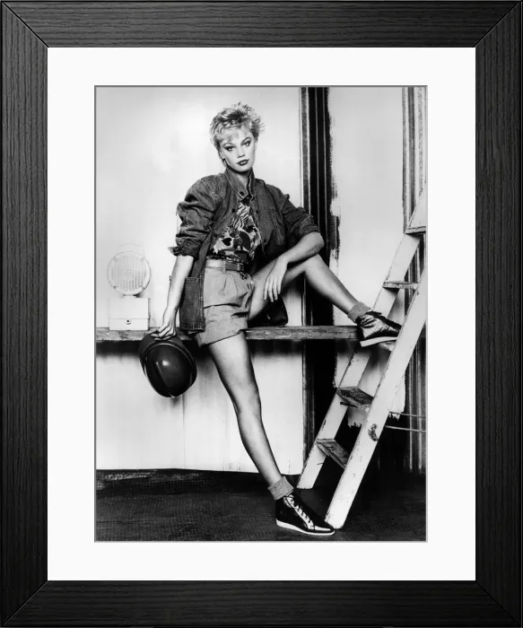 Framed Print : Shorts and Shapely. Model rests her foot on a ladder, holding a hard hat Framed Print : Shorts and Shapely. Model rests her foot on a ladder, holding a hard hat