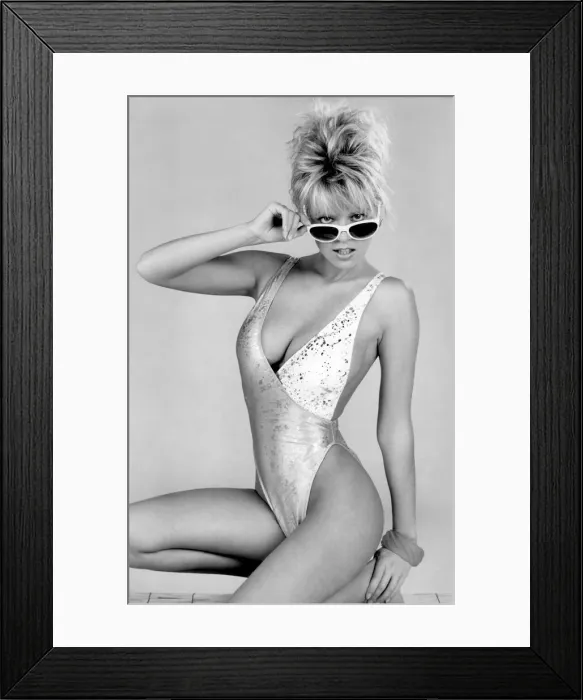 Framed Print : Clothing Beach: Woman models a low cut two-tone swimming costume slashed to stun