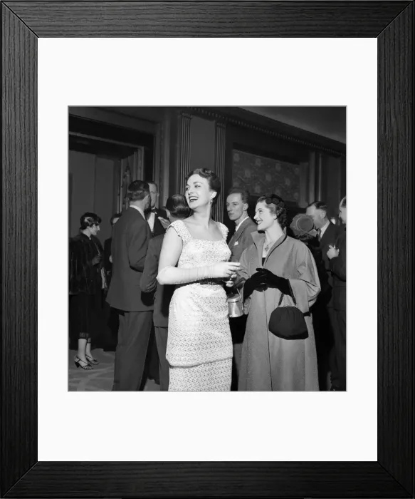 Framed Print : Woman wearing a white dress talking to other people at a cocktail Party