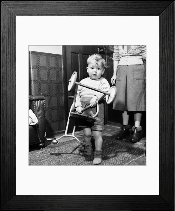 Framed Print : Young toddler boy holding a tricycle upside down December 1952 C6391-003 Framed Print : Young toddler boy holding a tricycle upside down December 1952 C6391-003