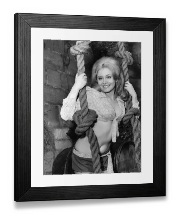 Framed Print : Woman wearing a tied shirt and shorts holding onto a pair of ropes Circa 1970