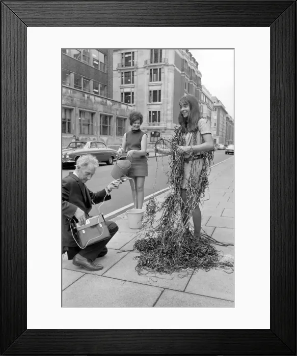 Framed Print : Harvey Morris recording Autumn leaves by a fountain with the aid of 22 year old Jane Framed Print : Harvey Morris recording Autumn leaves by a fountain with the aid of 22 year old Jane