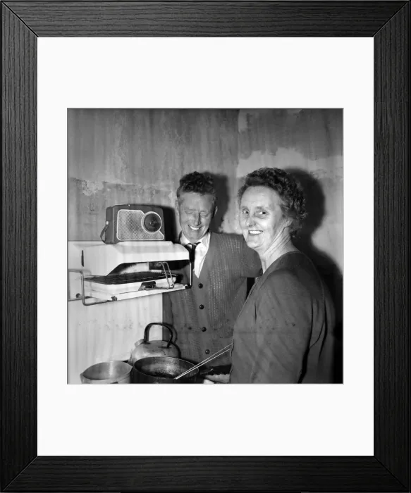 Framed Print : Housewife cooking dinner in her kitchen at home with her husband Framed Print : Housewife cooking dinner in her kitchen at home with her husband