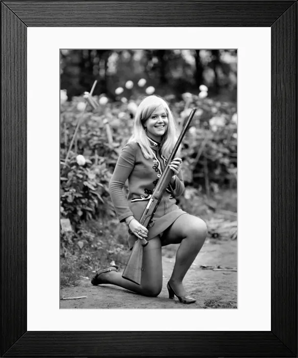 Framed Print : A woman posing wearing a mini dress and holding a shot gun November 1969 Framed Print : A woman posing wearing a mini dress and holding a shot gun November 1969