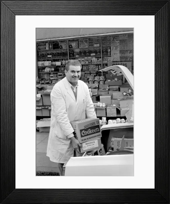 Framed Print : A man loading goods into the boot of his car in his shop at Deptford Framed Print : A man loading goods into the boot of his car in his shop at Deptford