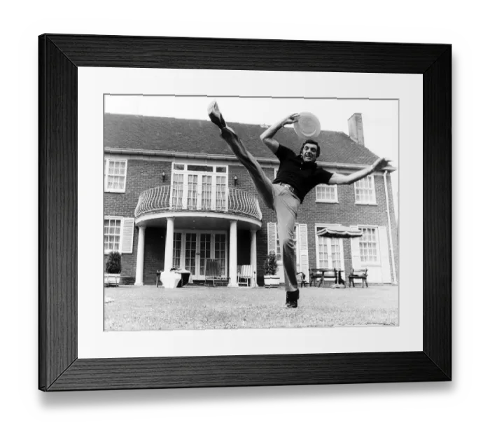 Framed Print : Frankie Vaughan singer does his high kick routine June 1974 holding his boater in