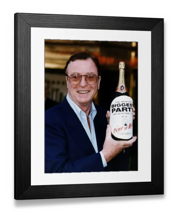 Framed Print : Michael Caine holding a large bottle of champagne Framed Print : Michael Caine holding a large bottle of champagne