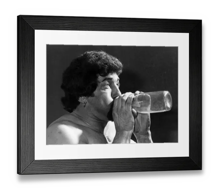 Framed Print : Male Stripper mel blowing into a milk bottle. June 1977 P018599 Framed Print : Male Stripper mel blowing into a milk bottle. June 1977 P018599