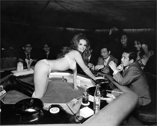 An English girl serves drinks to Hong Kong businessmen at the Bottoms Up Club