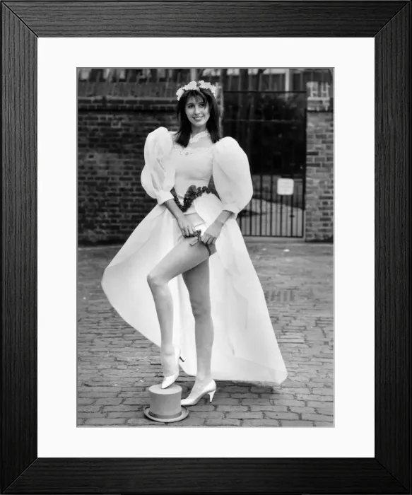 Framed Print : Fashion - wedding: leap up the aisle in a mini. Bride models a wedding dress with long Framed Print : Fashion - wedding: leap up the aisle in a mini. Bride models a wedding dress with long