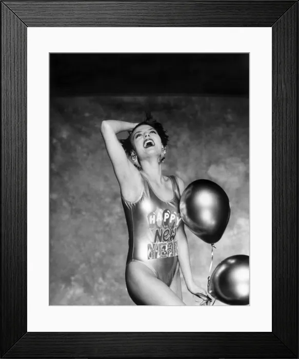 Framed Print : Clothing Beach. Woman models a shiny swimming costume with Happy New Year