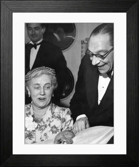 Framed Print : Man showing off a chicken drumstick to a woman at a dinner party Circa 1955