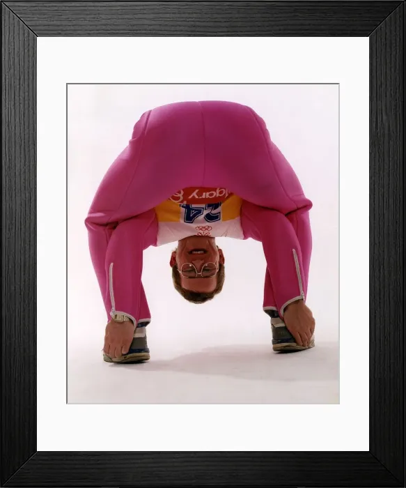 Framed Print : Eddie Edwards in pink ski clothing bending down and touching his heels Framed Print : Eddie Edwards in pink ski clothing bending down and touching his heels
