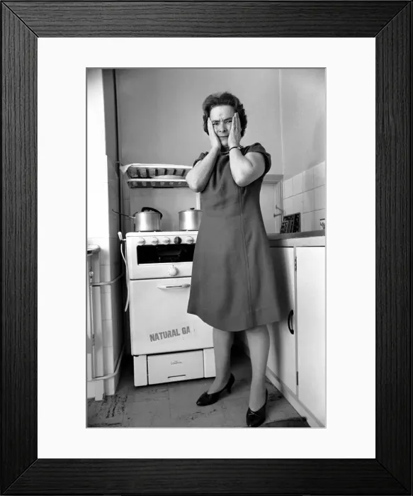 Framed Print : Household - Domestic Chores Cooking. A woman using her gas over in the kitchen of her Framed Print : Household - Domestic Chores Cooking. A woman using her gas over in the kitchen of her