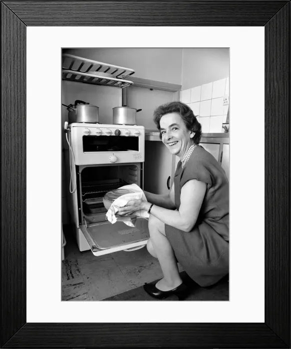 Framed Print : Household - Domestic Chores Cooking. A woman using her gas over in the kitchen of her Framed Print : Household - Domestic Chores Cooking. A woman using her gas over in the kitchen of her