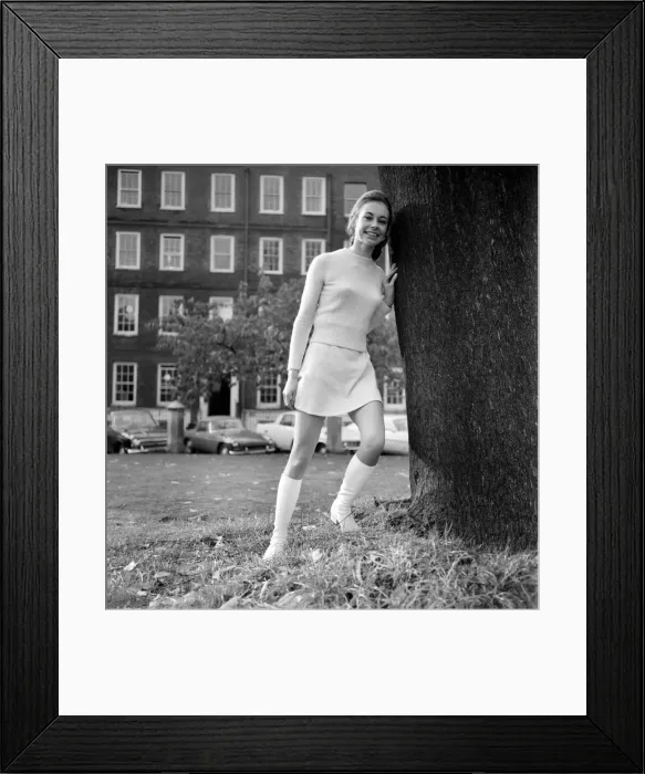 Framed Print : Woman wearing matching top, mini skirt and knee high looks poses for pictures Framed Print : Woman wearing matching top, mini skirt and knee high looks poses for pictures