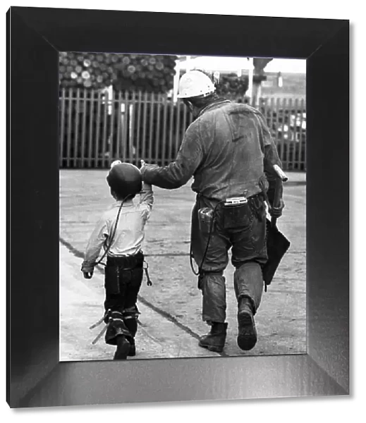 A coal miner walking his son, a junior miner. October 1978 P017740