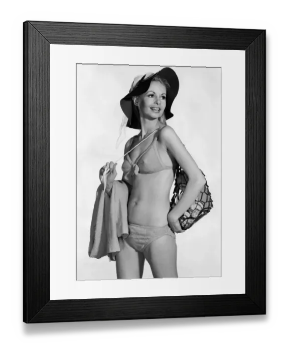 Framed Print : Model wearing a bikini. and hat, carrying a bag over her shoulder August 1970 Framed Print : Model wearing a bikini. and hat, carrying a bag over her shoulder August 1970