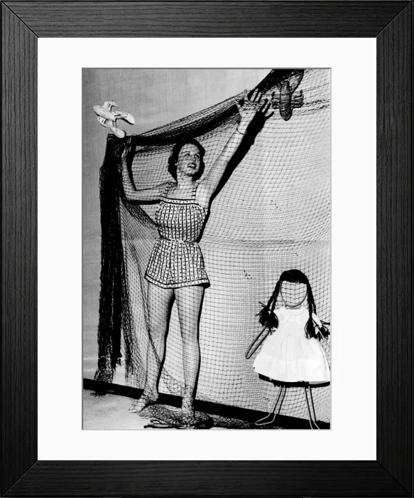 Framed Print : Woman wearing a short summer dress hangimg up netting November 1953 P017640
