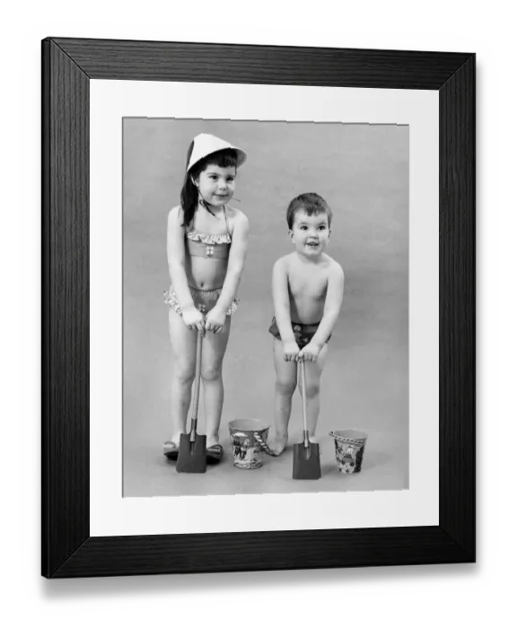 Framed Print : Fashion 1960s. Children play with bucket and spade in their swimwear Framed Print : Fashion 1960s. Children play with bucket and spade in their swimwear