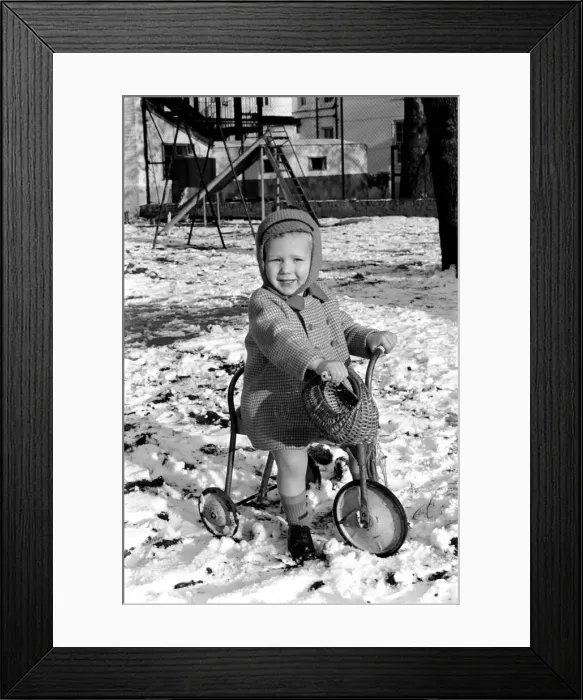 Framed Print : Young boy Robert playing on his bicycle in the snow. November 1969 Z11486