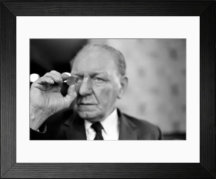 Framed Print : Elderly man studying a new fifty pence close up. November 1969 Z11025-002