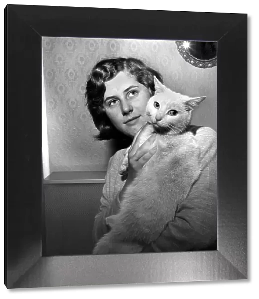 People with Animals: A Woman holding up her pet cat. November 1969 Z10902
