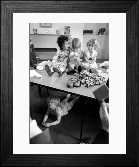 Framed Print : Away from the the crowd, this child model hides under the table It Framed Print : Away from the the crowd, this child model hides under the table It