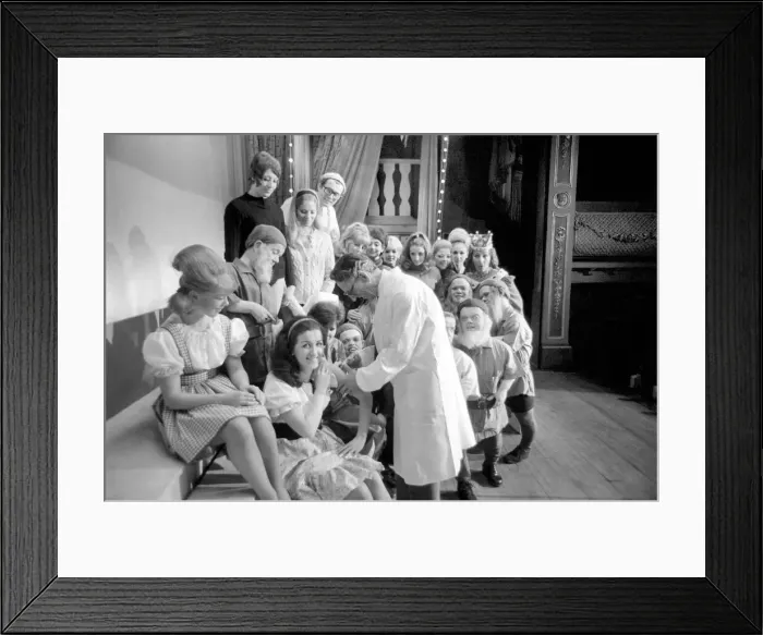 Framed Print : A doctor with his syringe makes ready to give anti-flu vaccine to Margaret Ayre