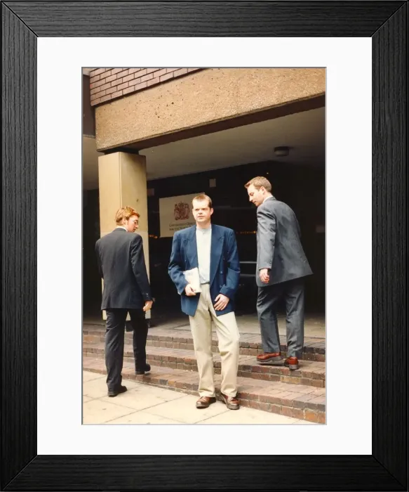 Framed Print : A young man posing in the latest work wear admired by his colleages