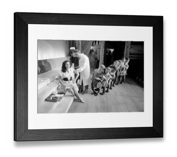 Framed Print : A doctor with his syringe makes ready to give anti-flu vaccine to Margaret Ayre Framed Print : A doctor with his syringe makes ready to give anti-flu vaccine to Margaret Ayre