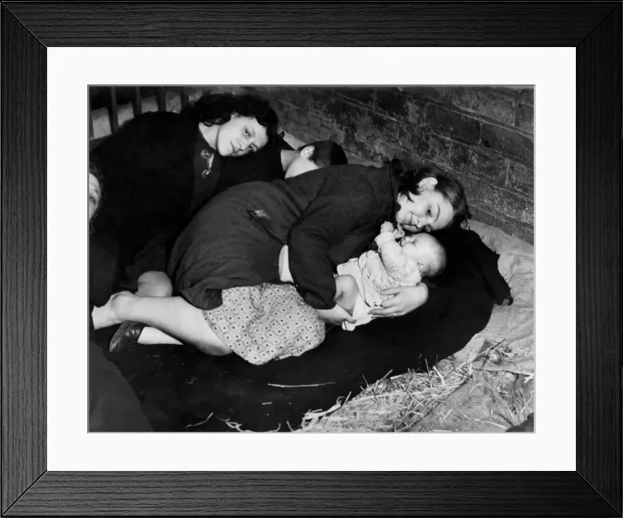 Framed Print : A Mother protects her baby whilst taking cover from air raid in a farmers barn