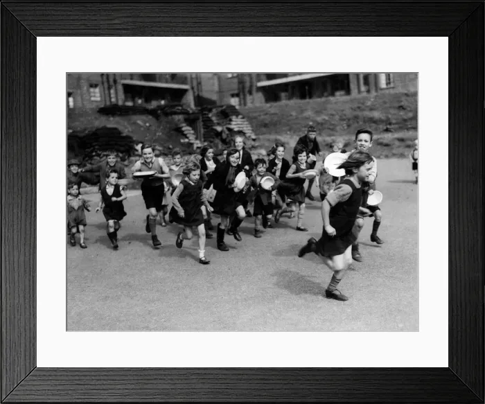 Framed Print : Food glorious food. Children run for lunch at a communal feeding station