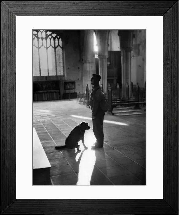 Framed Print : A moment of quiet reflection for a civil defence worker and his rescue dog in a church