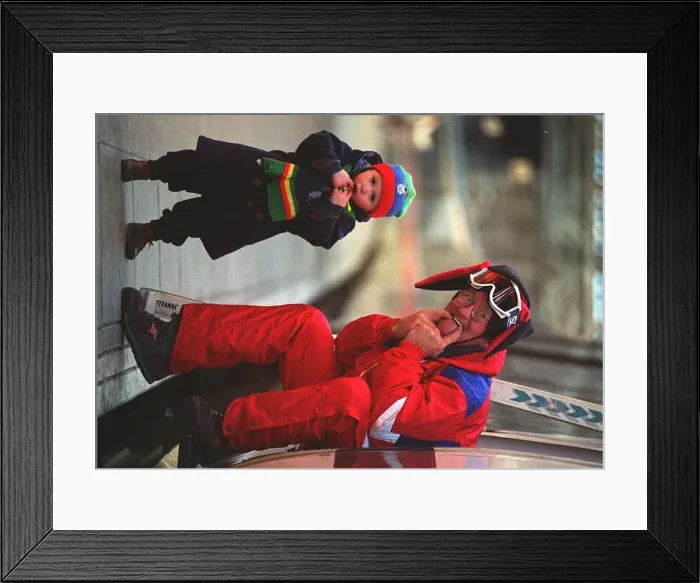 Framed Print : Eddie Edwards in red ski suit, Eddie the Eagle Edwards making friends with 2 year old