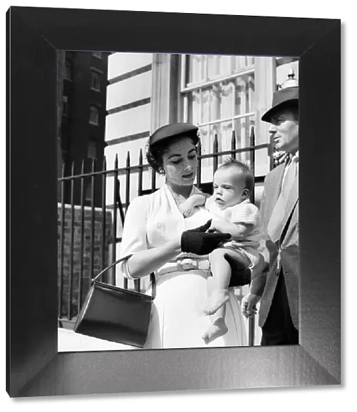 Elizabeth Taylor with the baby and Michael Wilding on the steps of the apartment