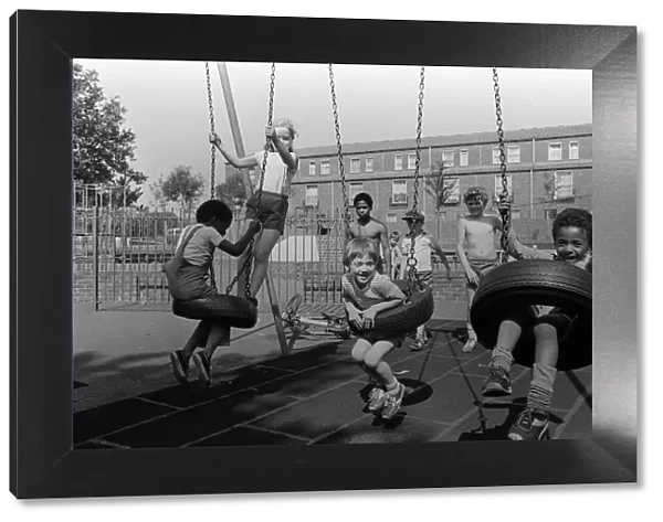 Notting Hill Carnival August 1981 Children playing on the swings in the recreation