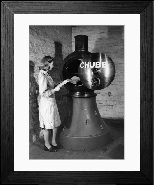 Framed Print : The 2 1  /  2 ton Revolving Lighthouse Safe. Here a woman is seen placing papers in