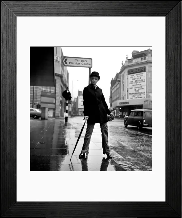 Framed Print : Fashion: Clothing. Unisex clothes. A girl wears a bowler hat, dark overcoat, pin stripes Framed Print : Fashion: Clothing. Unisex clothes. A girl wears a bowler hat, dark overcoat, pin stripes