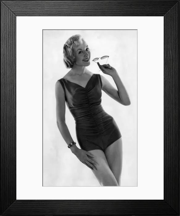 Framed Print : Woman wearing a swimsuit and holding a pair of sunglasses September 1958