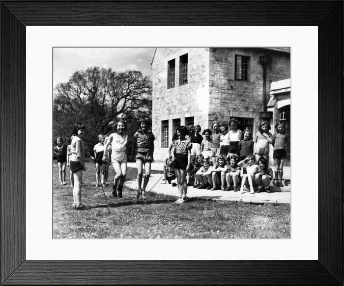 Framed Print : Girls skipping outside on the front lawn. Circa 1950 P012106 Framed Print : Girls skipping outside on the front lawn. Circa 1950 P012106