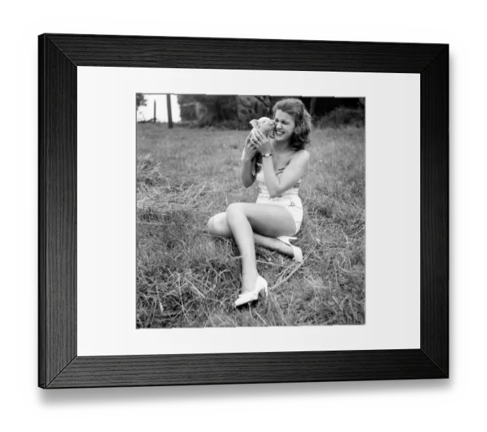 Framed Print : Animals: Pigs: Syd Owen with a month-old piglet, the smallest of another litter which she